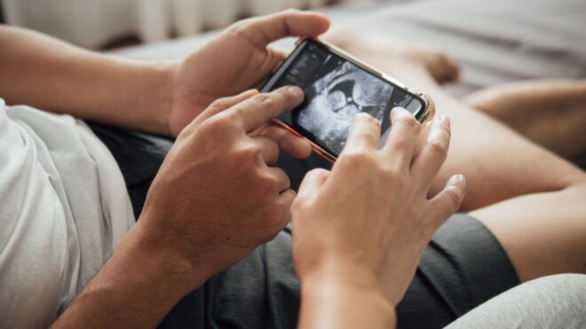 mom and dad looking at baby ultrasound
