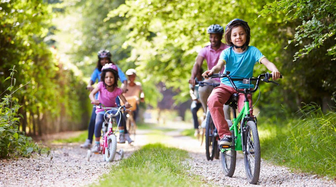 multigeneration-family-riding-on-bikes-through-a-forest-picture-id460549519.jpg