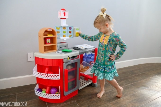 Little girl with interactive grocery toy