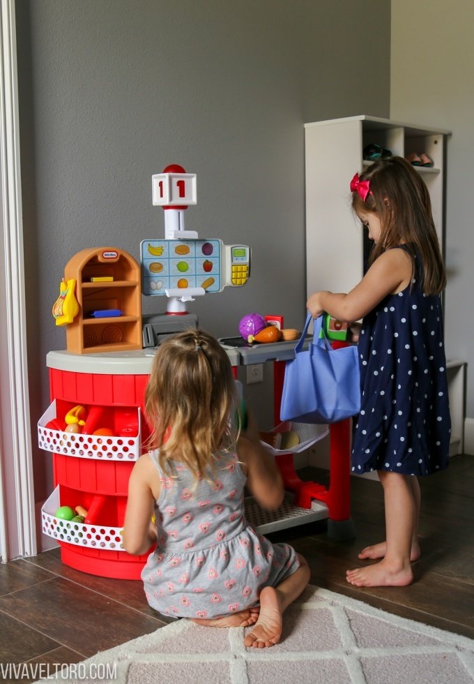 Two little girls playing with grocery store