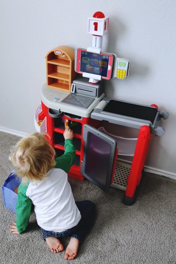 Toddler playing with LIttle Tikes Shop n' Learn Smart Checkout