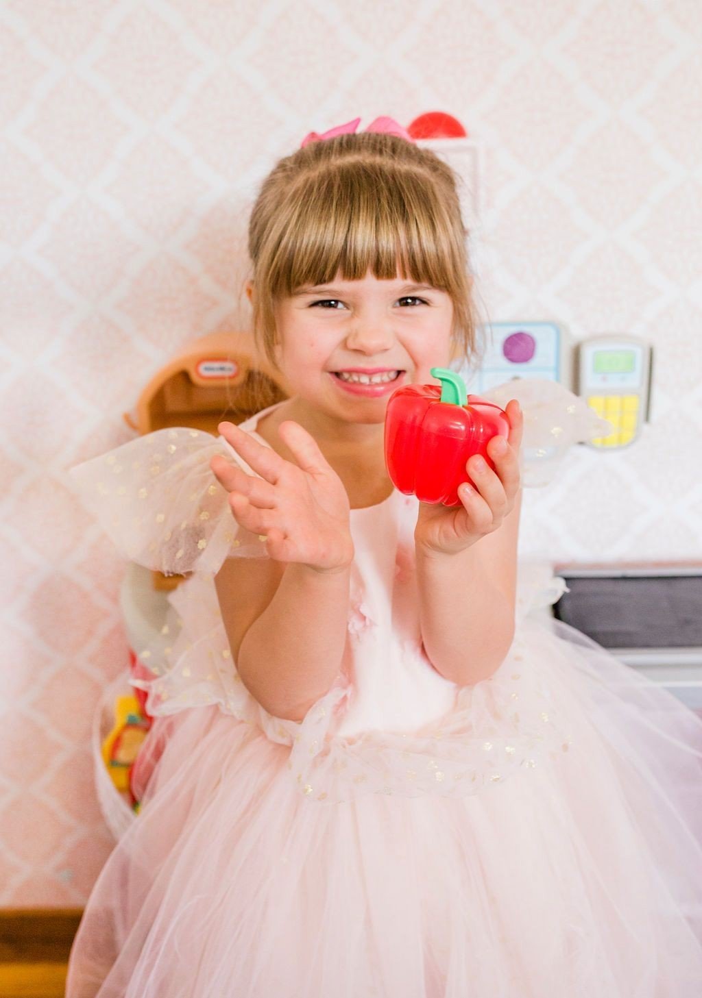 little girl holding Little Tikes grocery item