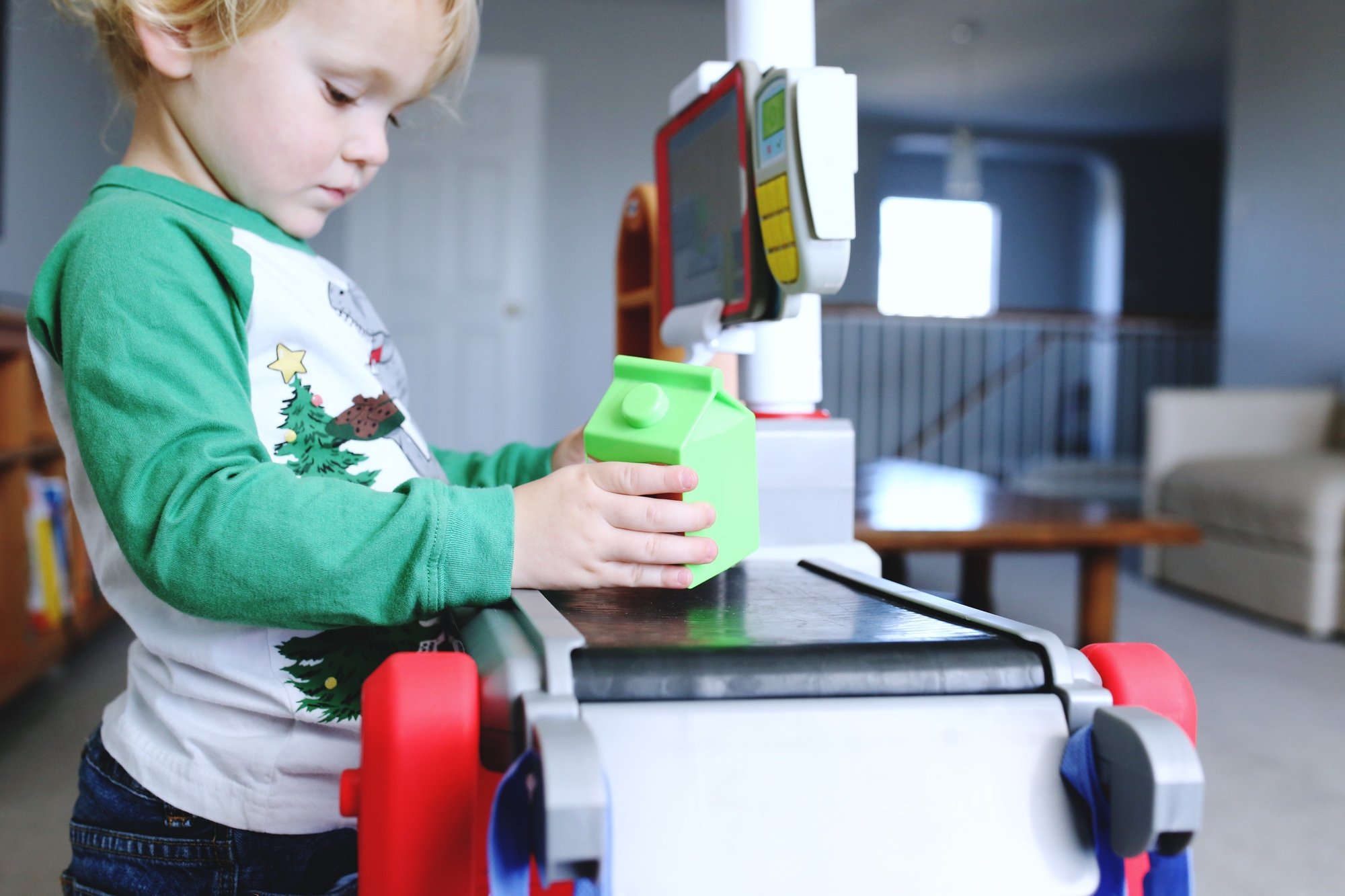 Toddler boy scanning pretend groceries