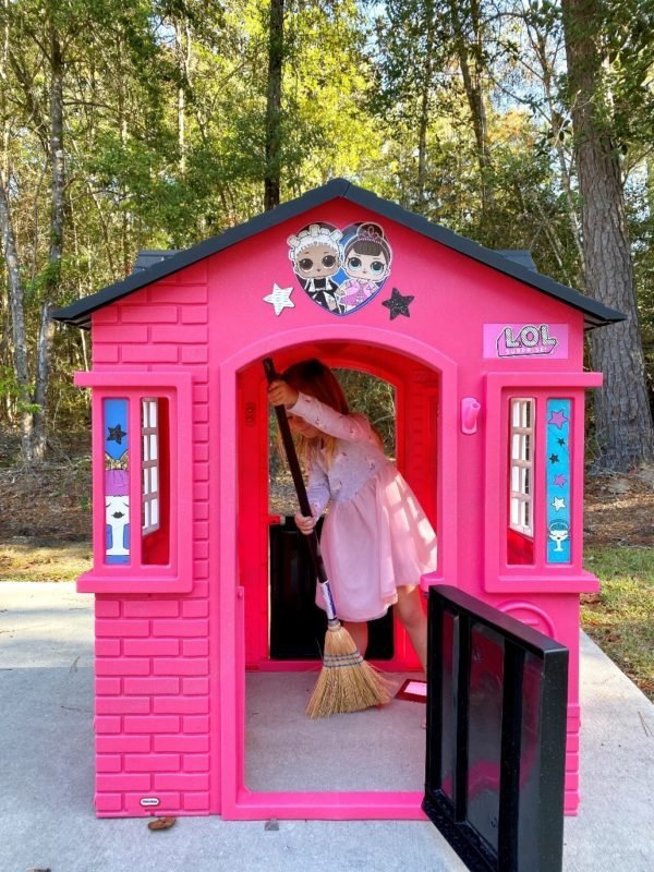 Little girl sweeping in LOL Surprise Cottage Playhouse