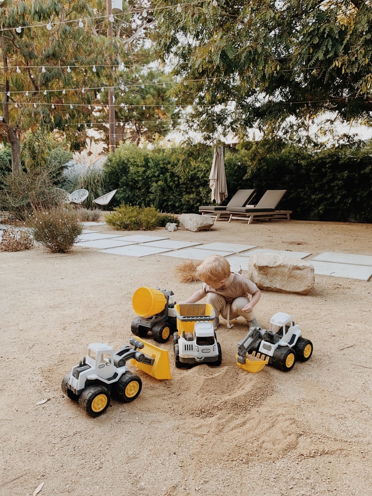 Toddler playing with trucks in dirt