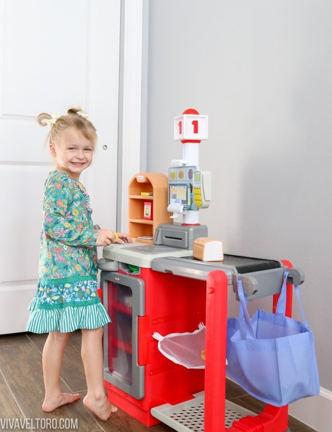 Little girl playing with Little Tikes checkout