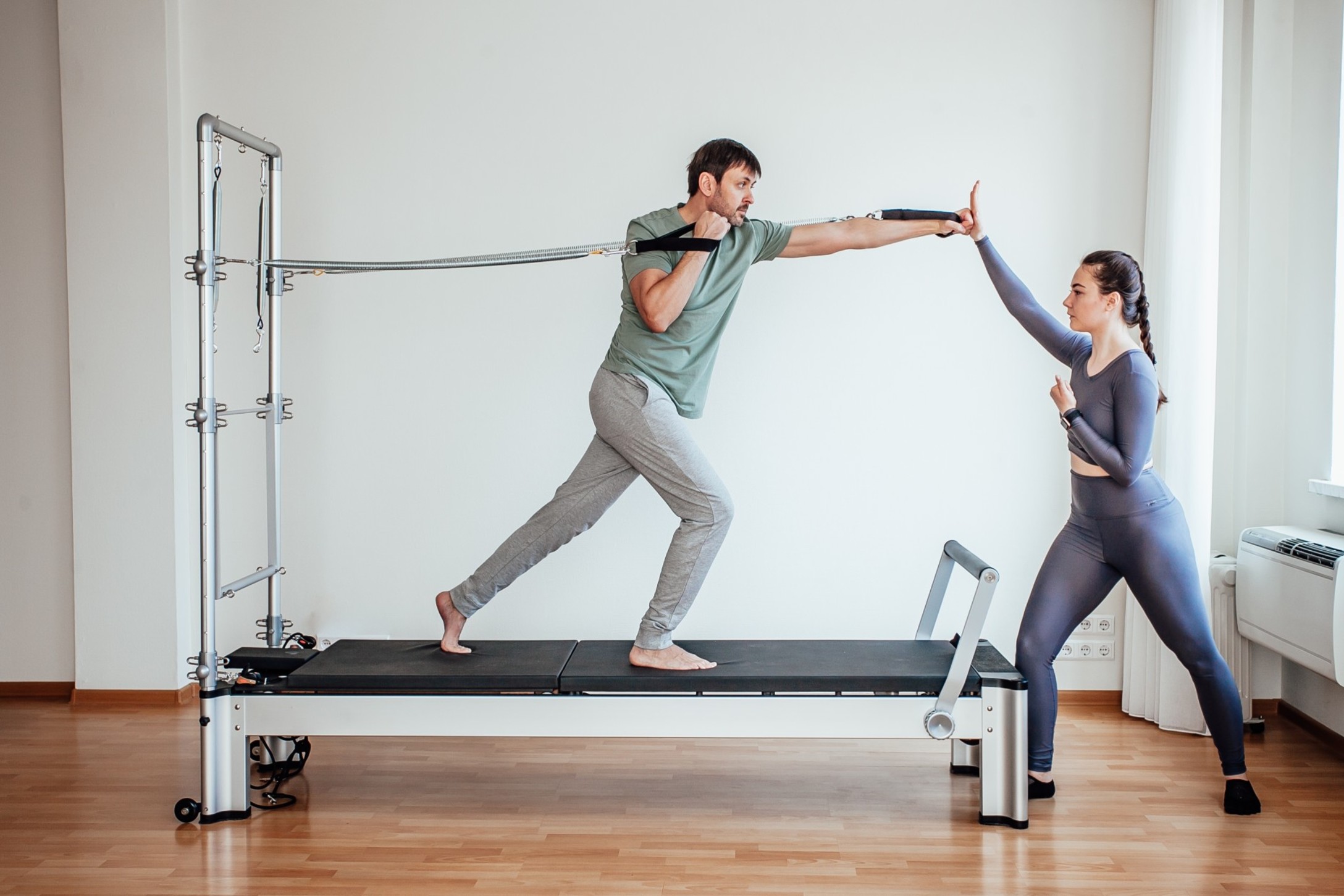 reformer-pilates-an-attractive-man-working-out-with-a-pilates-instructor-in-the-gym_t20_gz9oez.jpg
