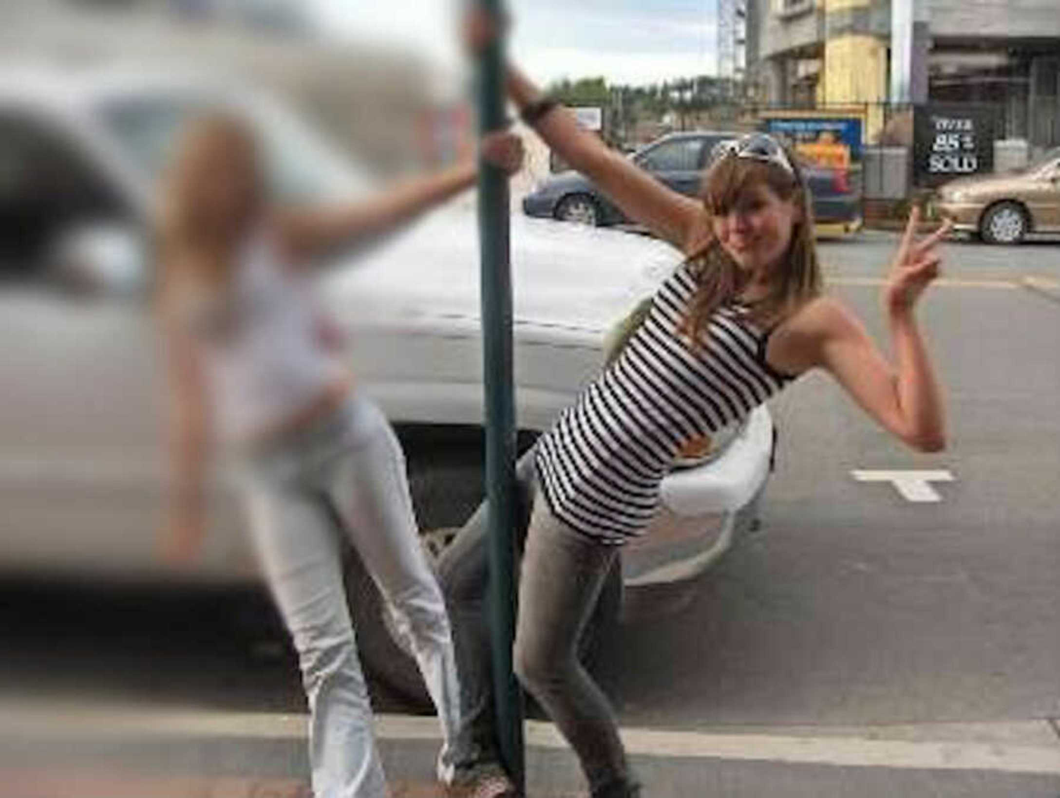 teenage-girls-hanging-on-pole-on-sidewalk-900x678-1.jpg