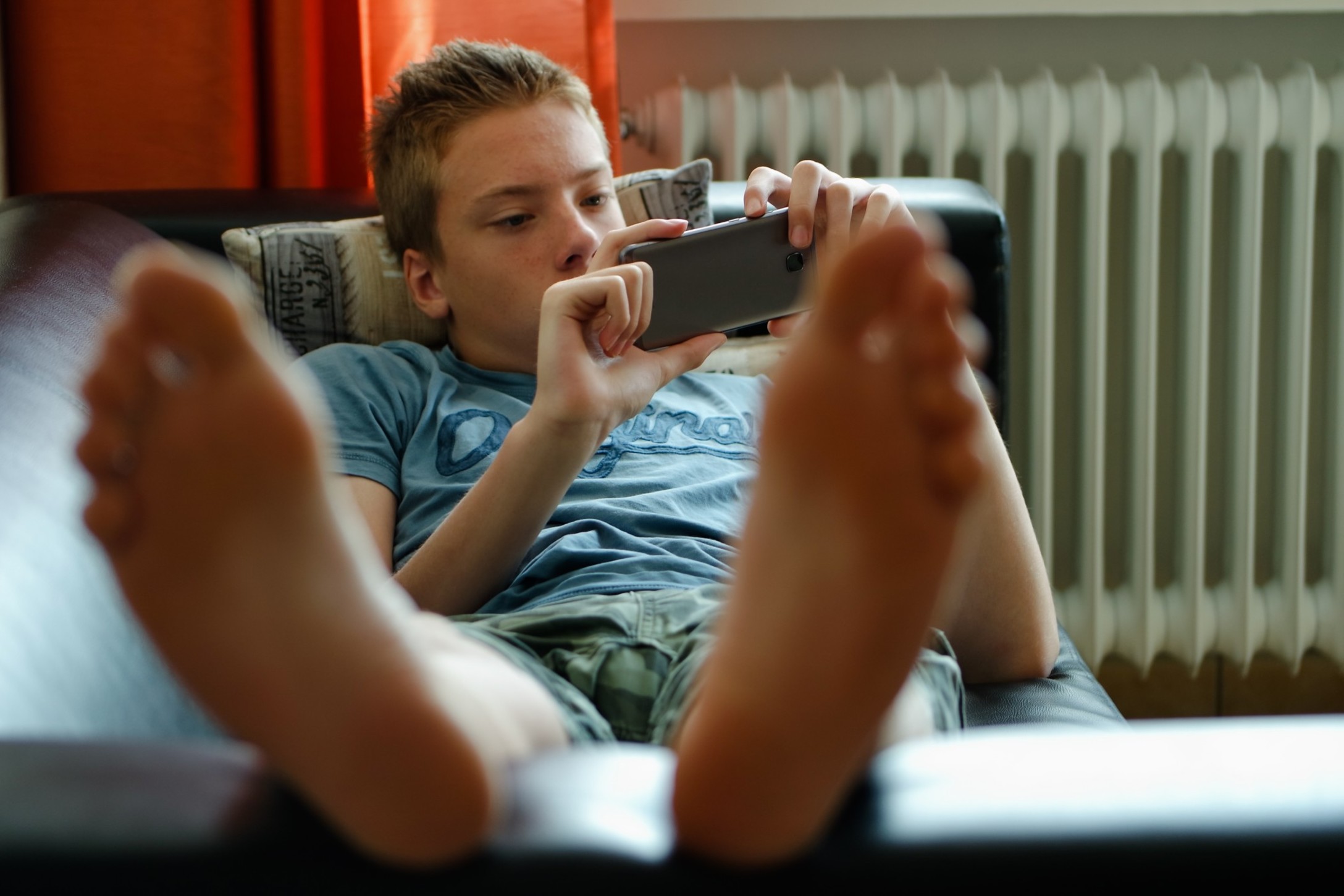 teenager-boy-laying-on-the-couch-and-using-mobile-phone_t20_V7ZNR7.jpg