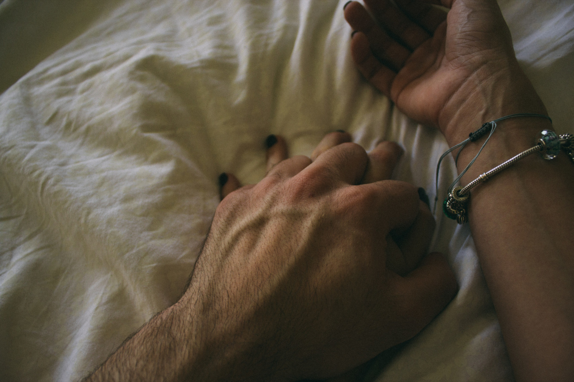 the-hands-of-a-couple-fitting-while-they-are-lying-down-on-a-bed_t20_d1wRab.jpg