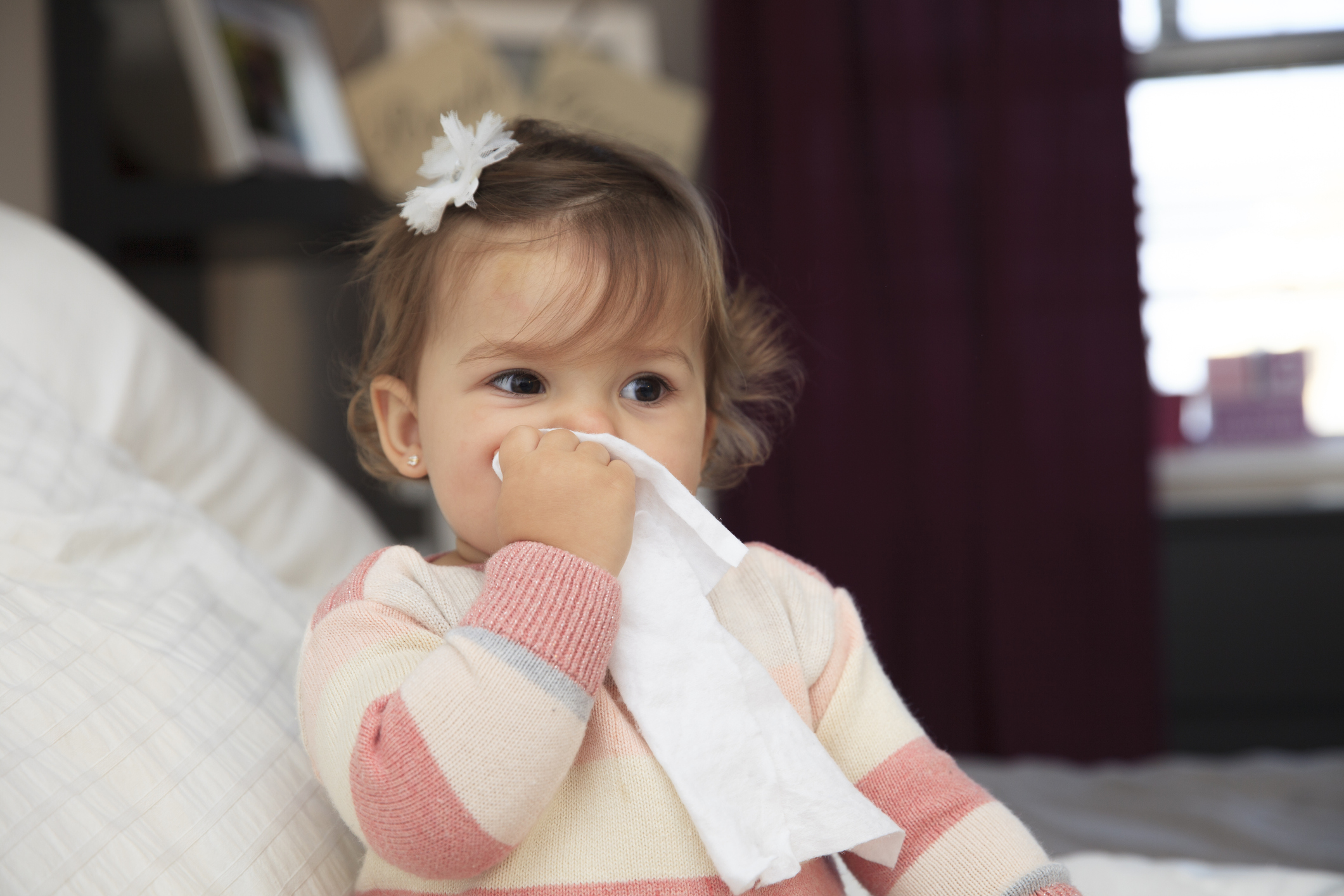 Little girl wiping her nose