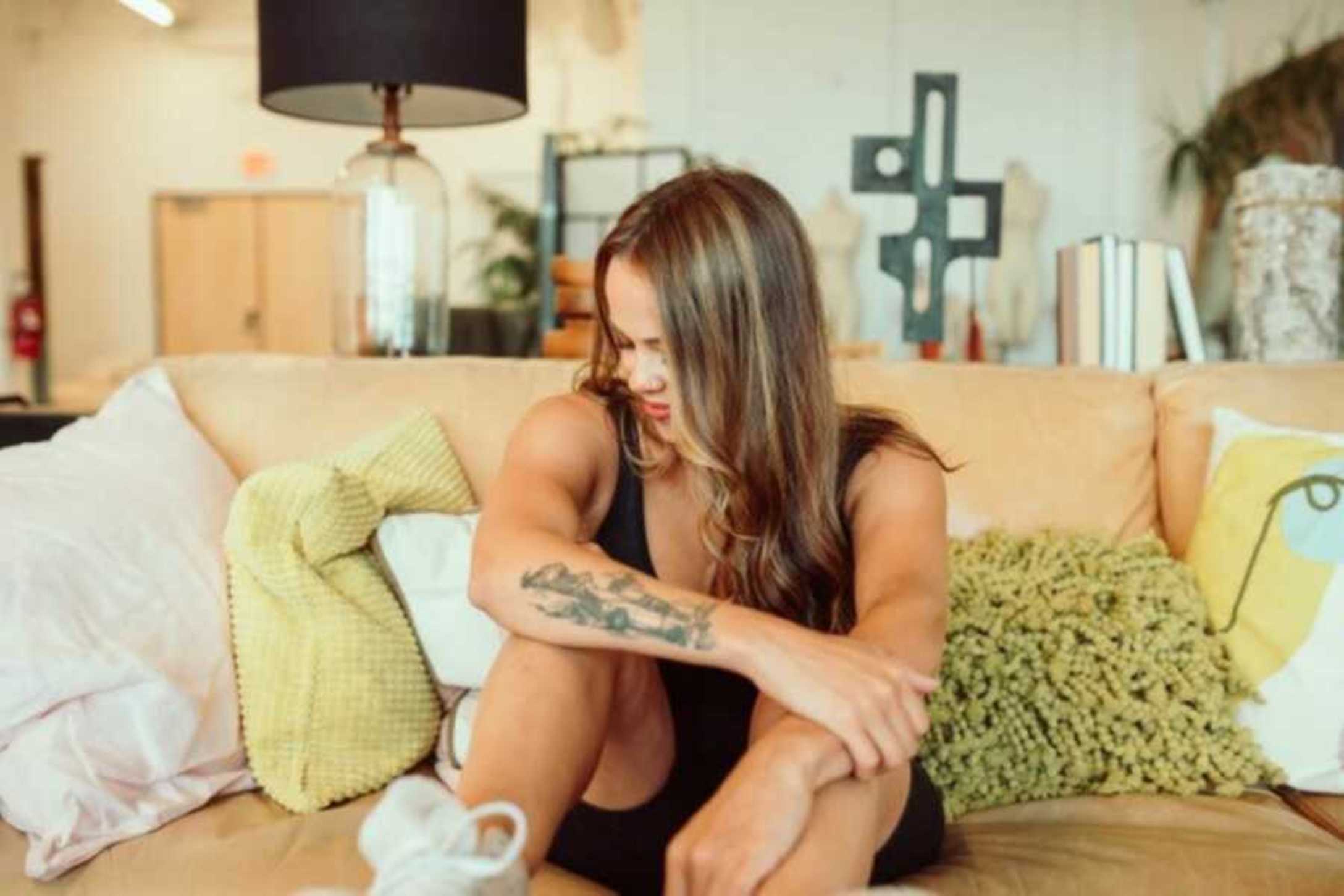 woman-sitting-on-cream-couch-with-arm-tattoo-900x600-1.jpg