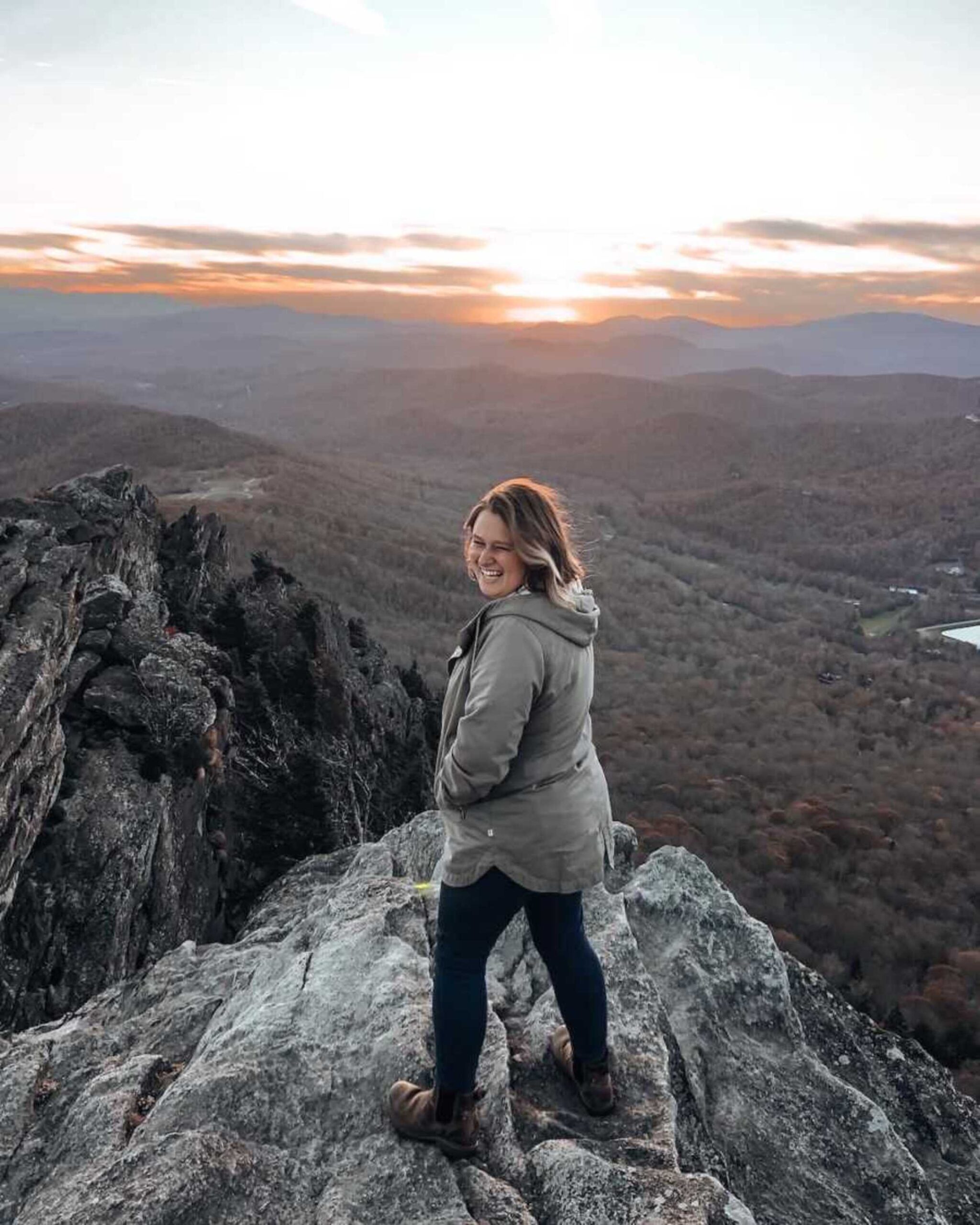 woman-stands-at-mountain-peak-smiling-900x1125-1.jpeg