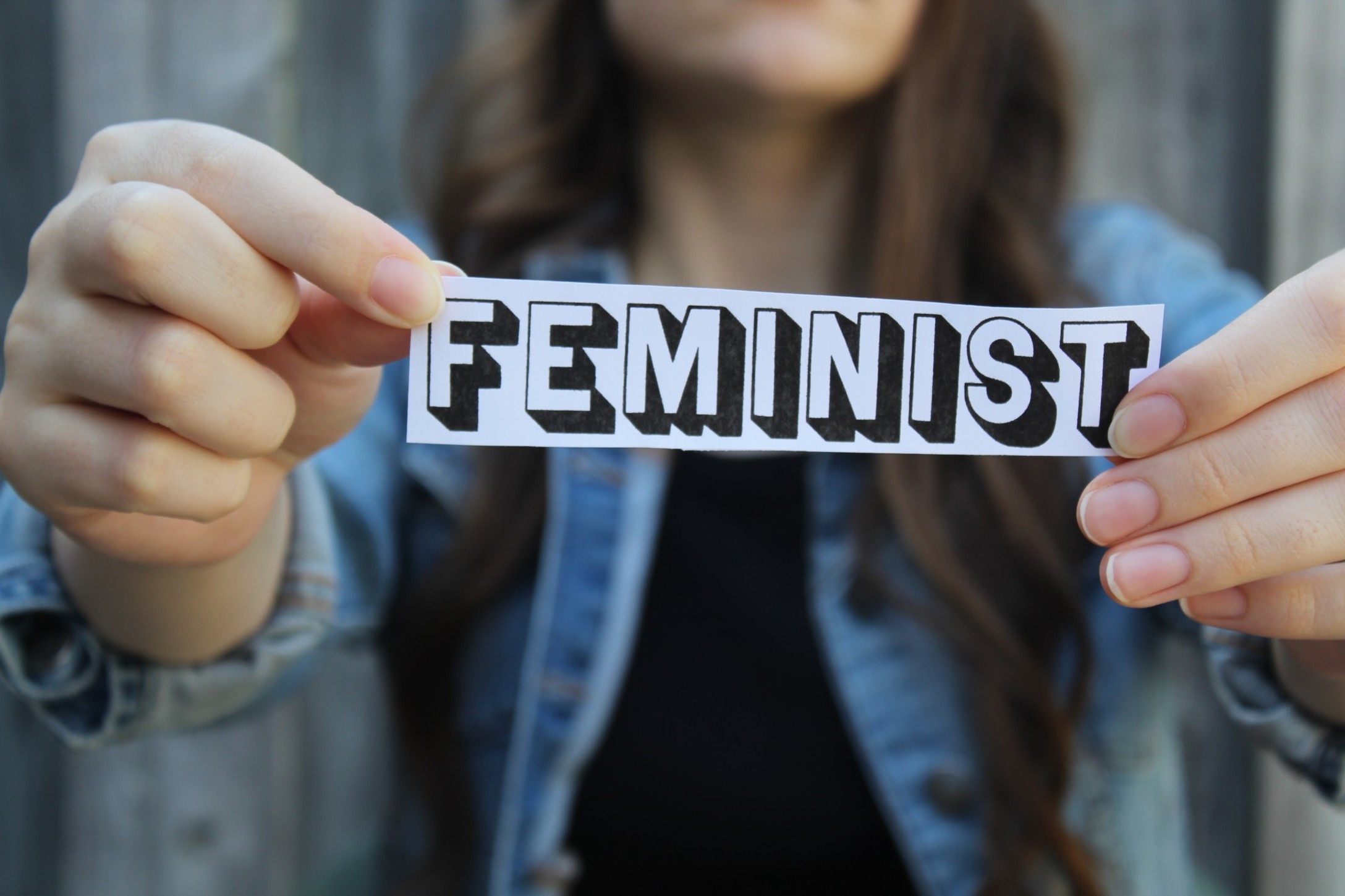 womans-hands-holding-paper-with-the-word-feminst_t20_0XpOEV-1.jpg