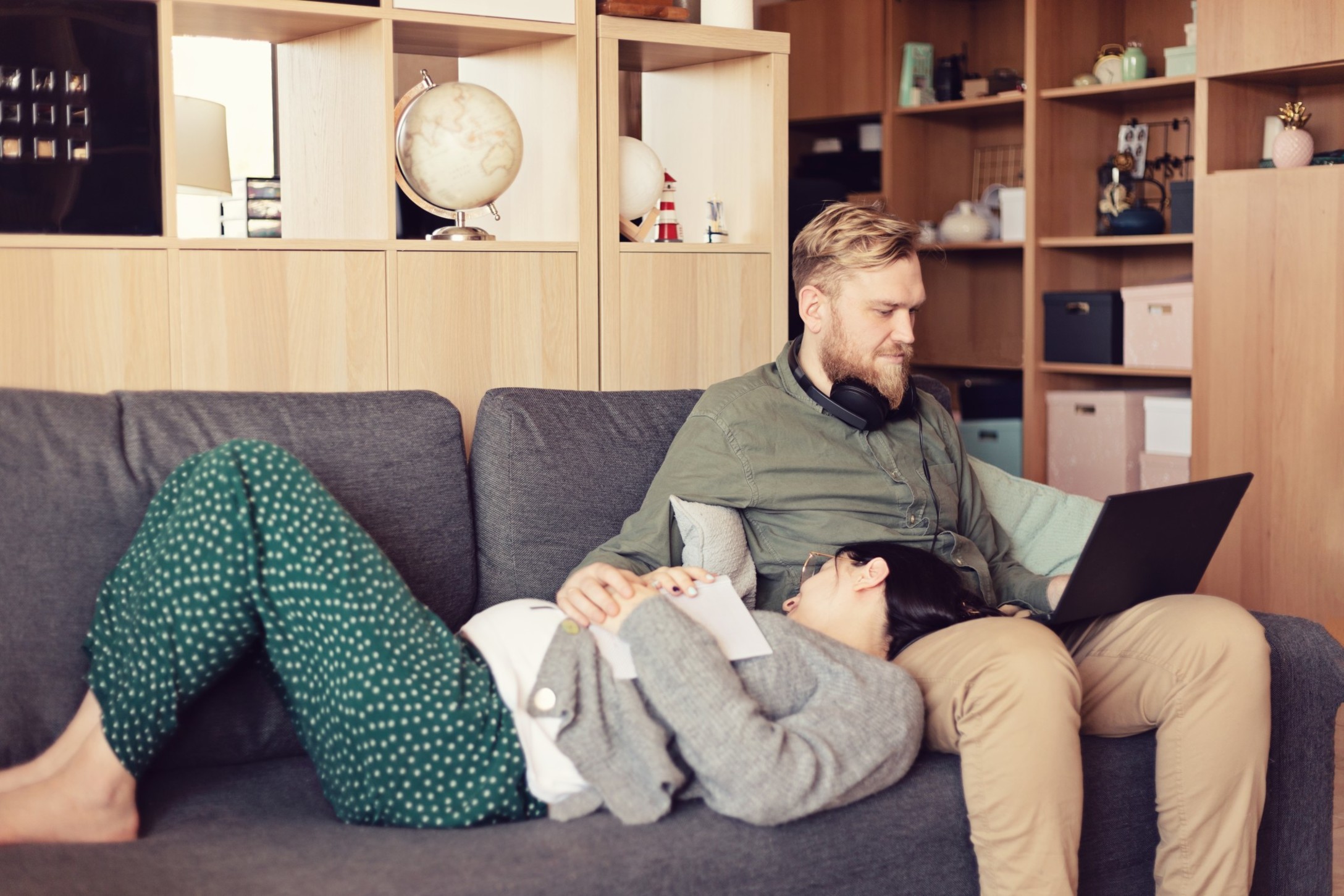 young-couple-on-the-coach-husband-working-with-his-laptop-and-pregnant-wife-relaxing-on-his-knees_t20_jL0N0d.jpg