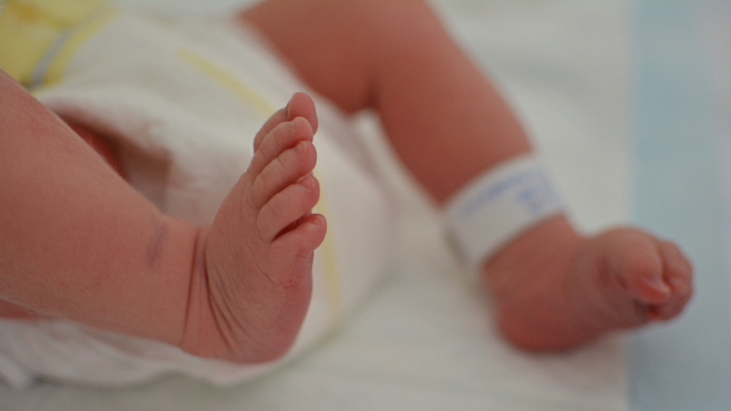 newborn feet with a hospital bracelet around one ankle