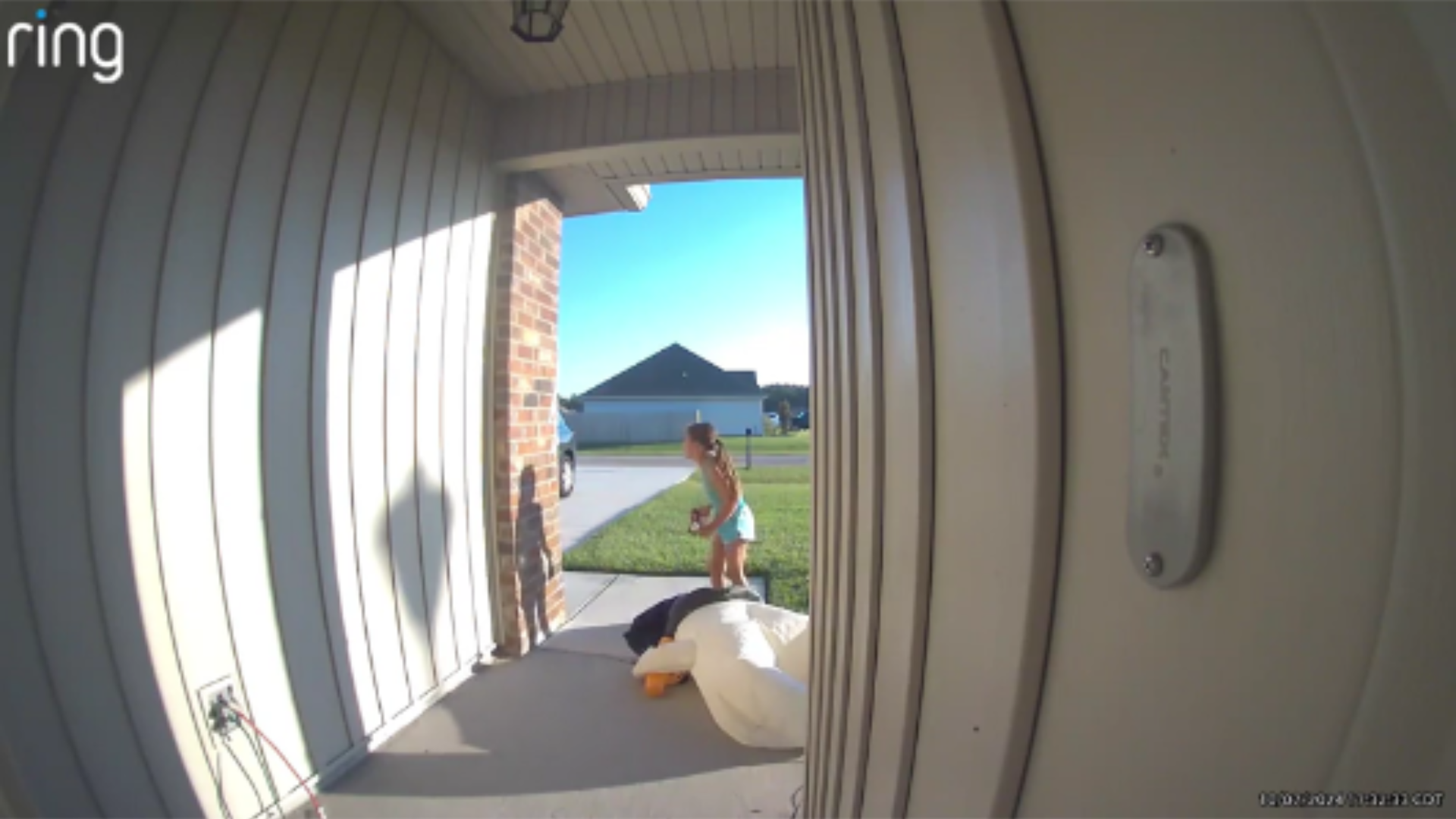 girl in tank top and blue shorts running away from front door with her back to camera