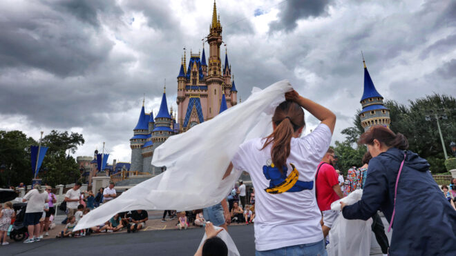 Guests at the Magic Kingdom break out ponchos at Cinderella Castle as bands of weather from Hurricane Helene move through Walt Disney World in Bay Lake, Florida, on Sept. 26, 2024. (Joe Burbank/Orlando Sentinel/TNS)