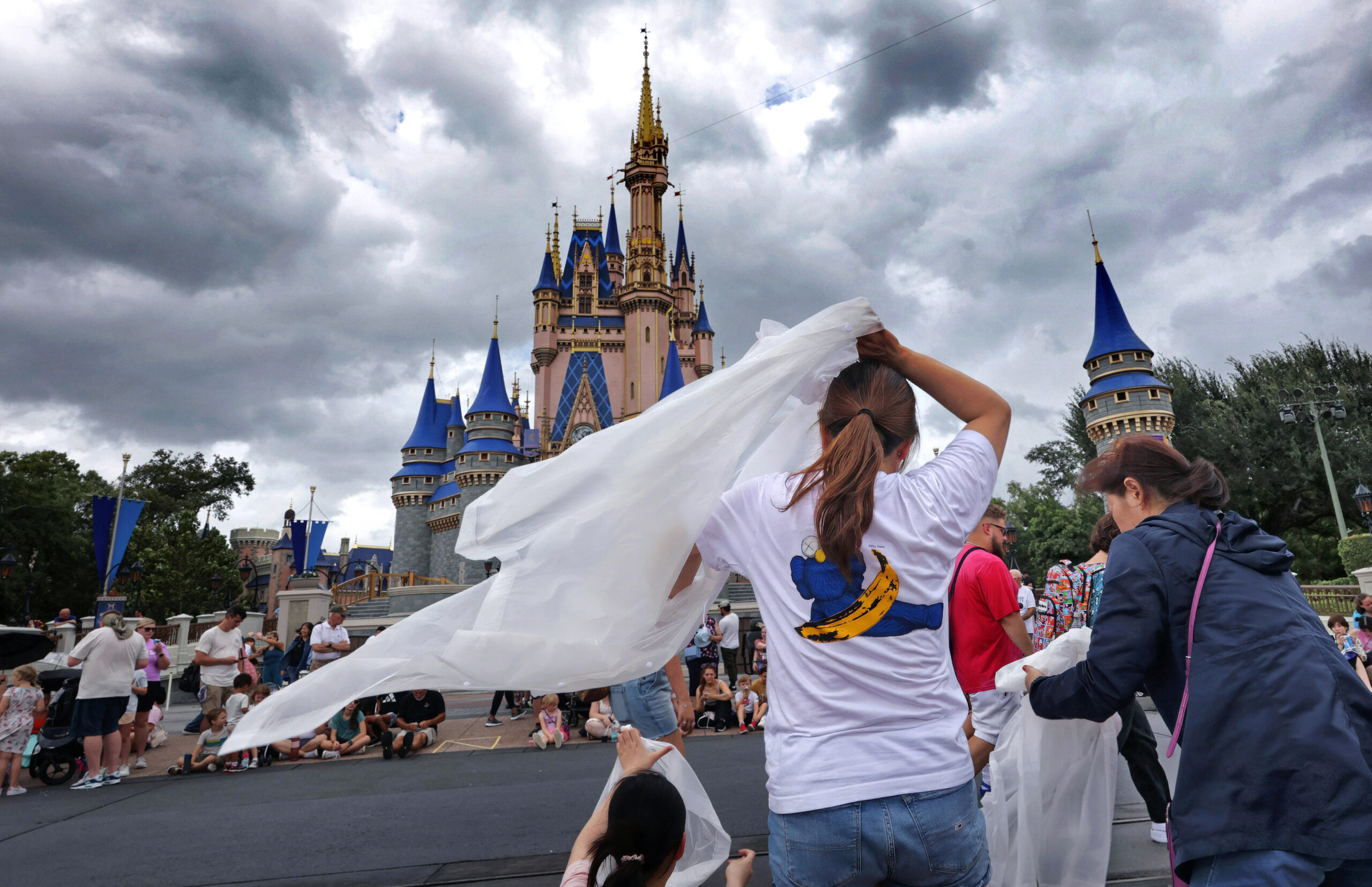 Guests at the Magic Kingdom break out ponchos at Cinderella Castle as bands of weather from Hurricane Helene move through Walt Disney World in Bay Lake, Florida, on Sept. 26, 2024. (Joe Burbank/Orlando Sentinel/TNS)