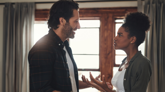 couple arguing in front of window