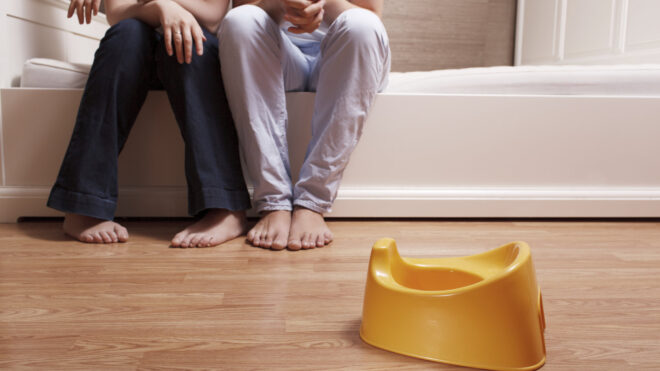parents sitting near a child's potty