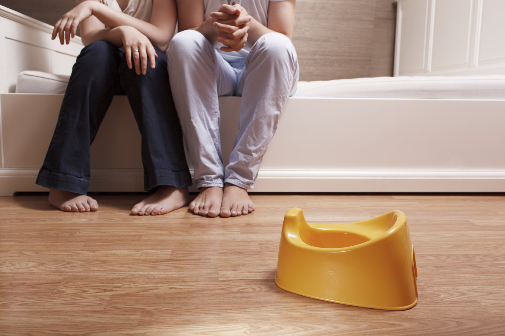 parents sitting near a child's potty