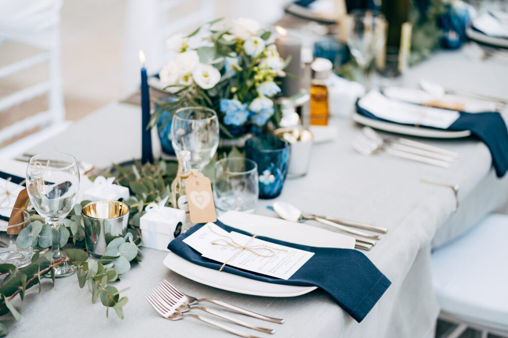 Tables decorated with flowers, knives, forks and plates for a wedding reception
