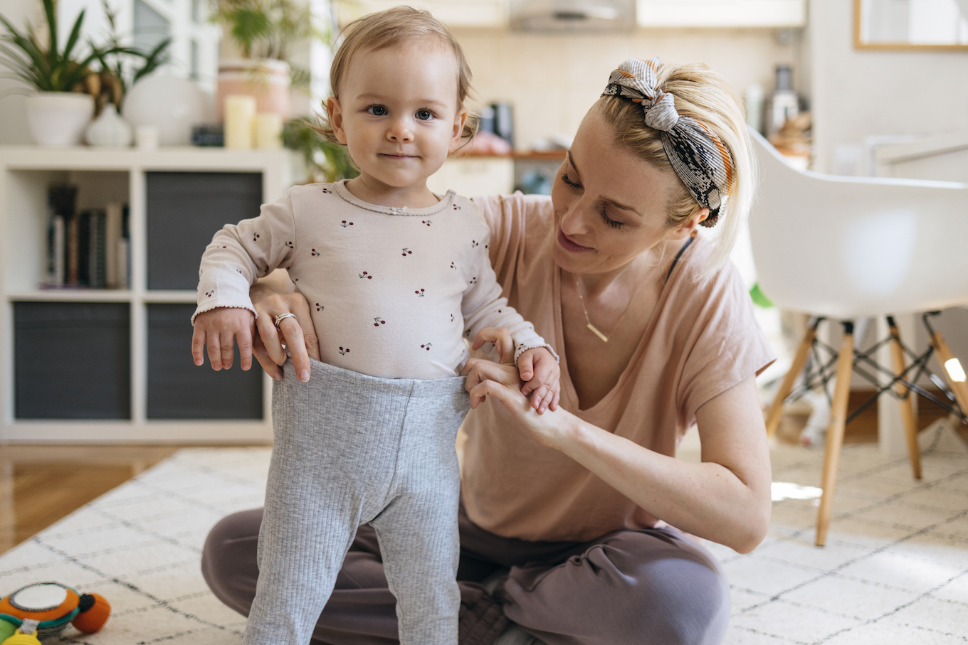 Mom dressing her child