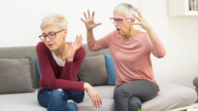 woman with short hair and glasses ignoring older woman also with short hair and glasses who looks angry