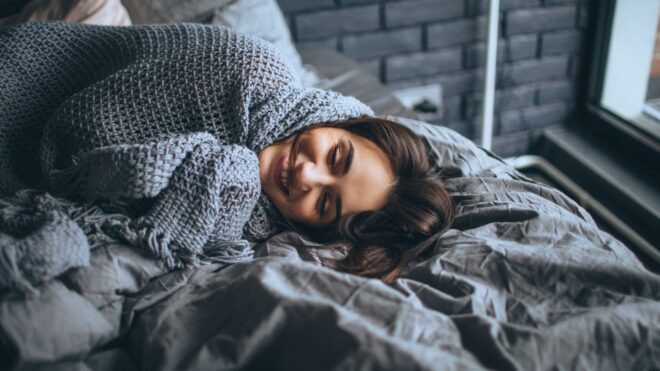 woman in bed under blanket