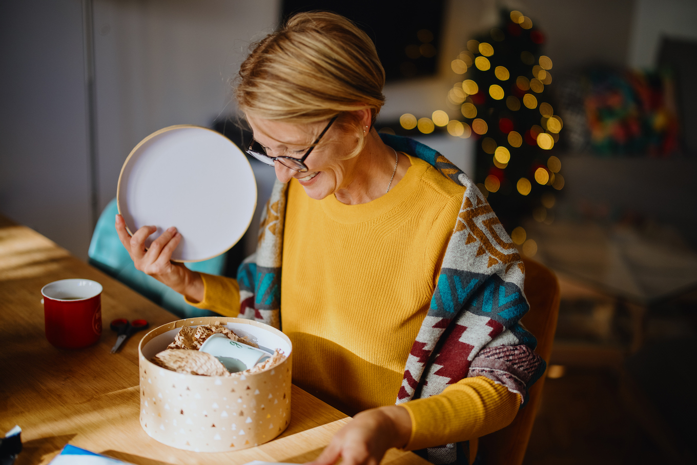 Smiling woman unpacking christmas box