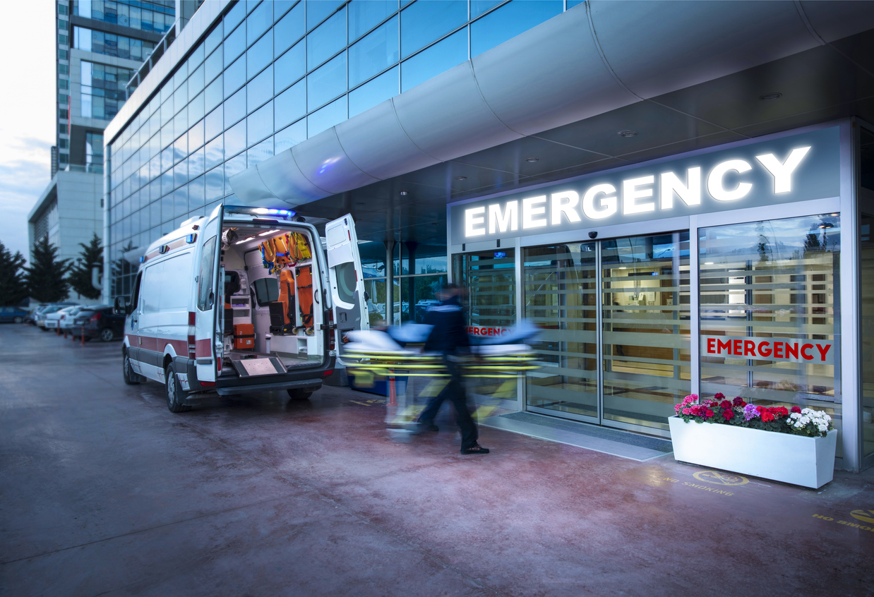 Paramedics taking patient on stretcher from ambulance to hospital