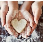 Hands baking and holding a heart shape