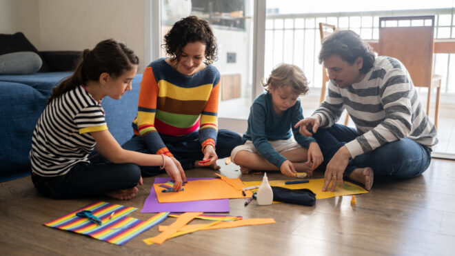 Family together sitting on the floor doing art's project at home