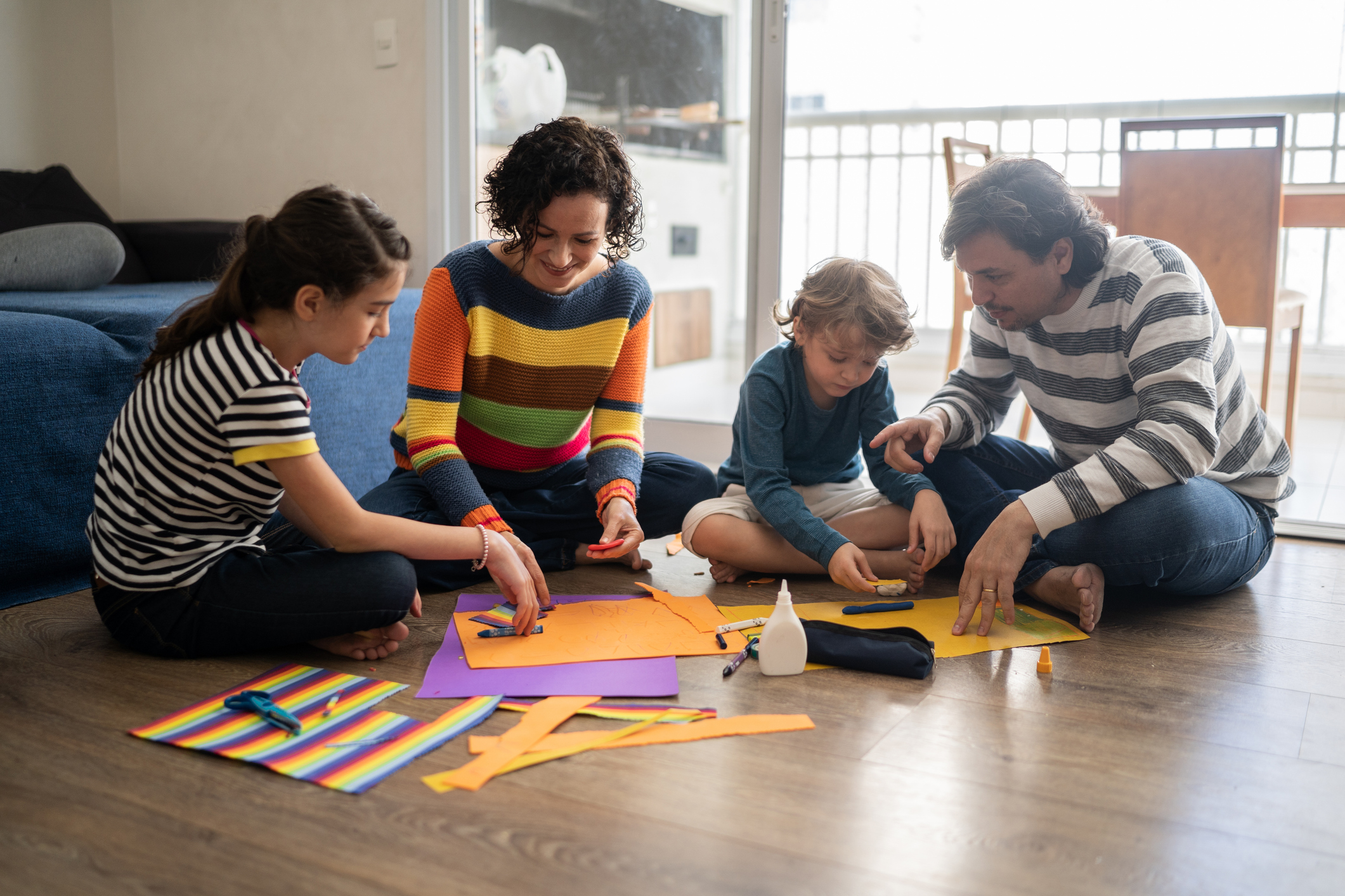 Family together sitting on the floor doing art's project at home