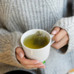 Female hands with cup of hot tea