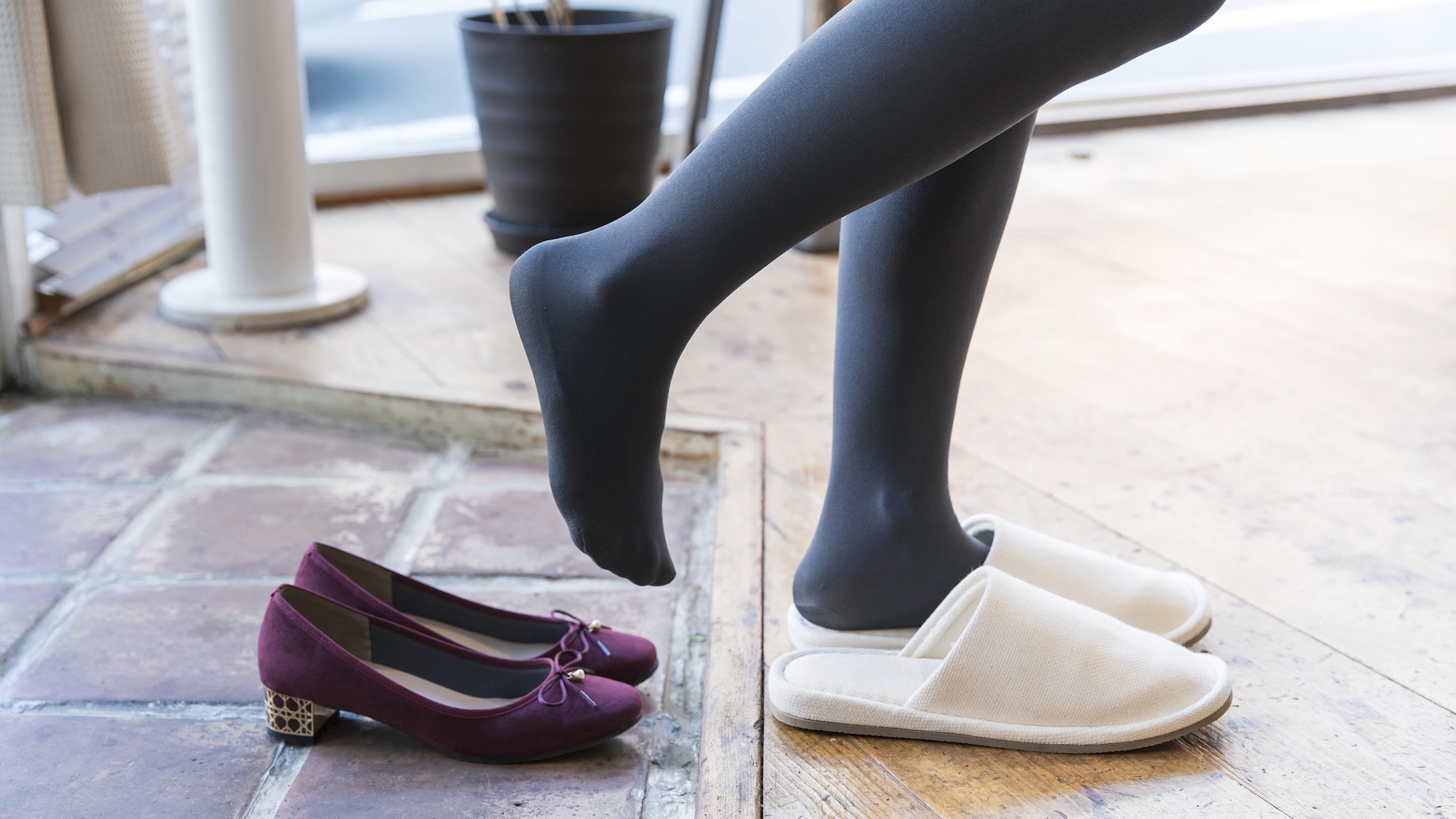 someone taking off shoes inside a house and putting on slippers