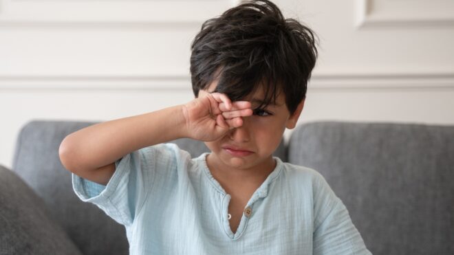 Cute little boy crying at home