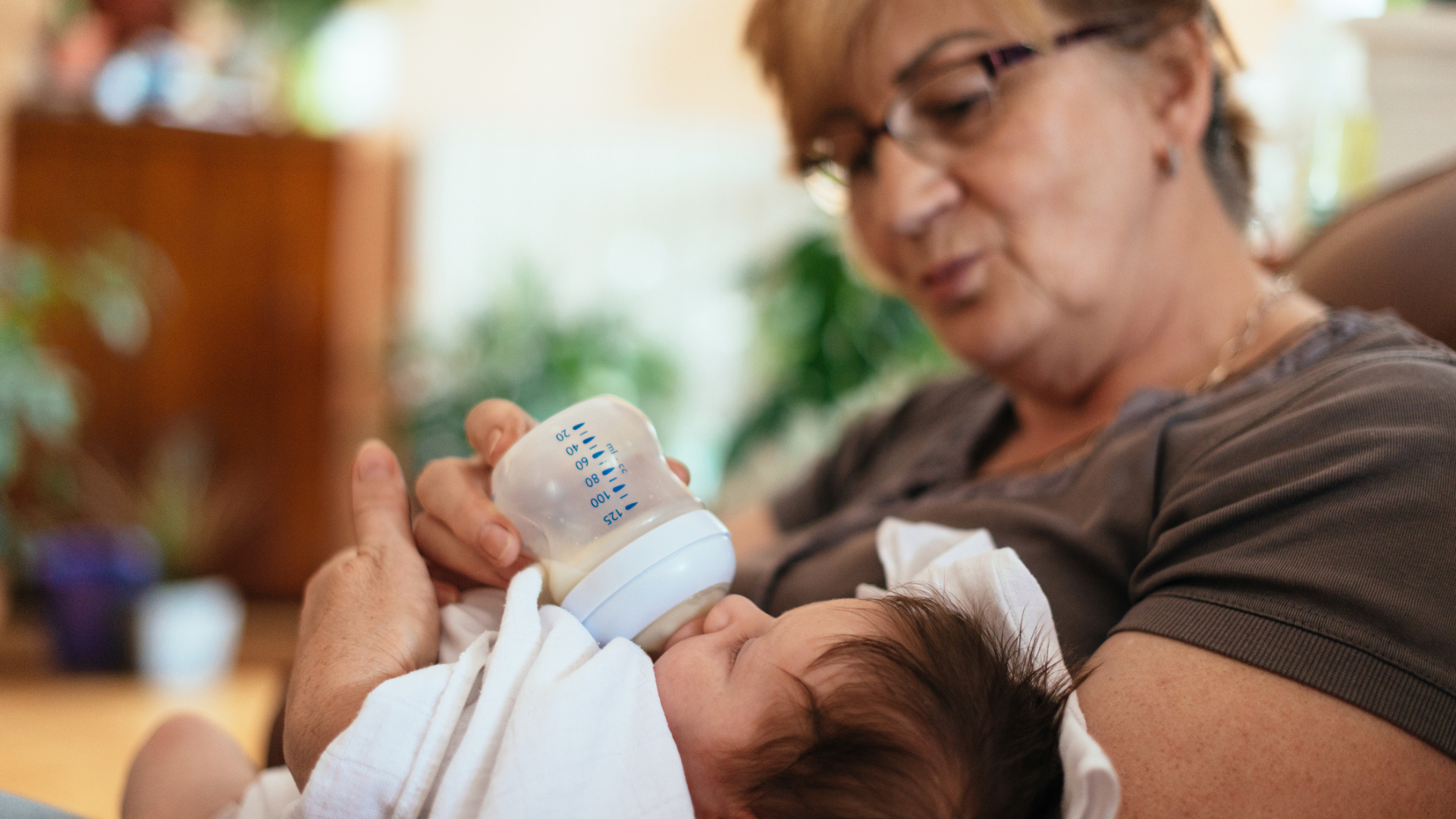 grandma feeding baby a bottle