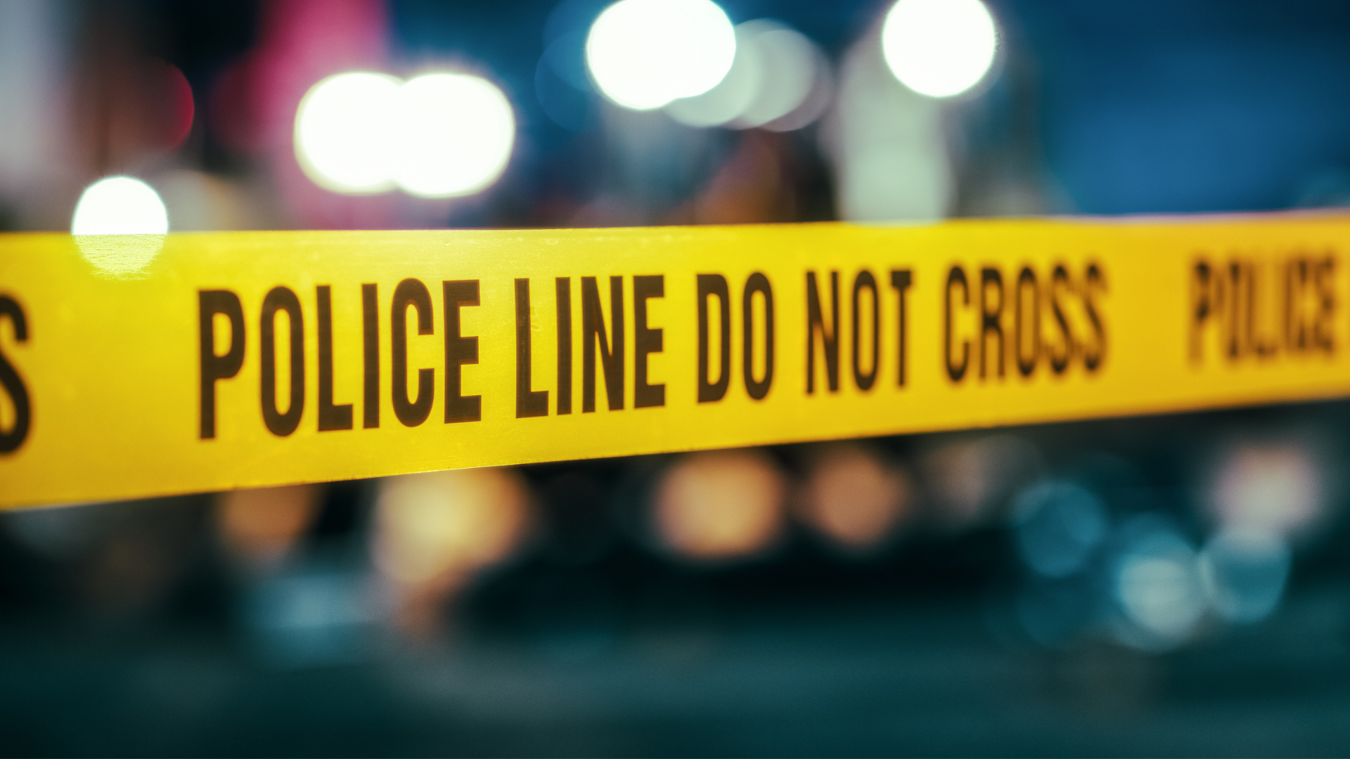 yellow police tape in front of distorted lights