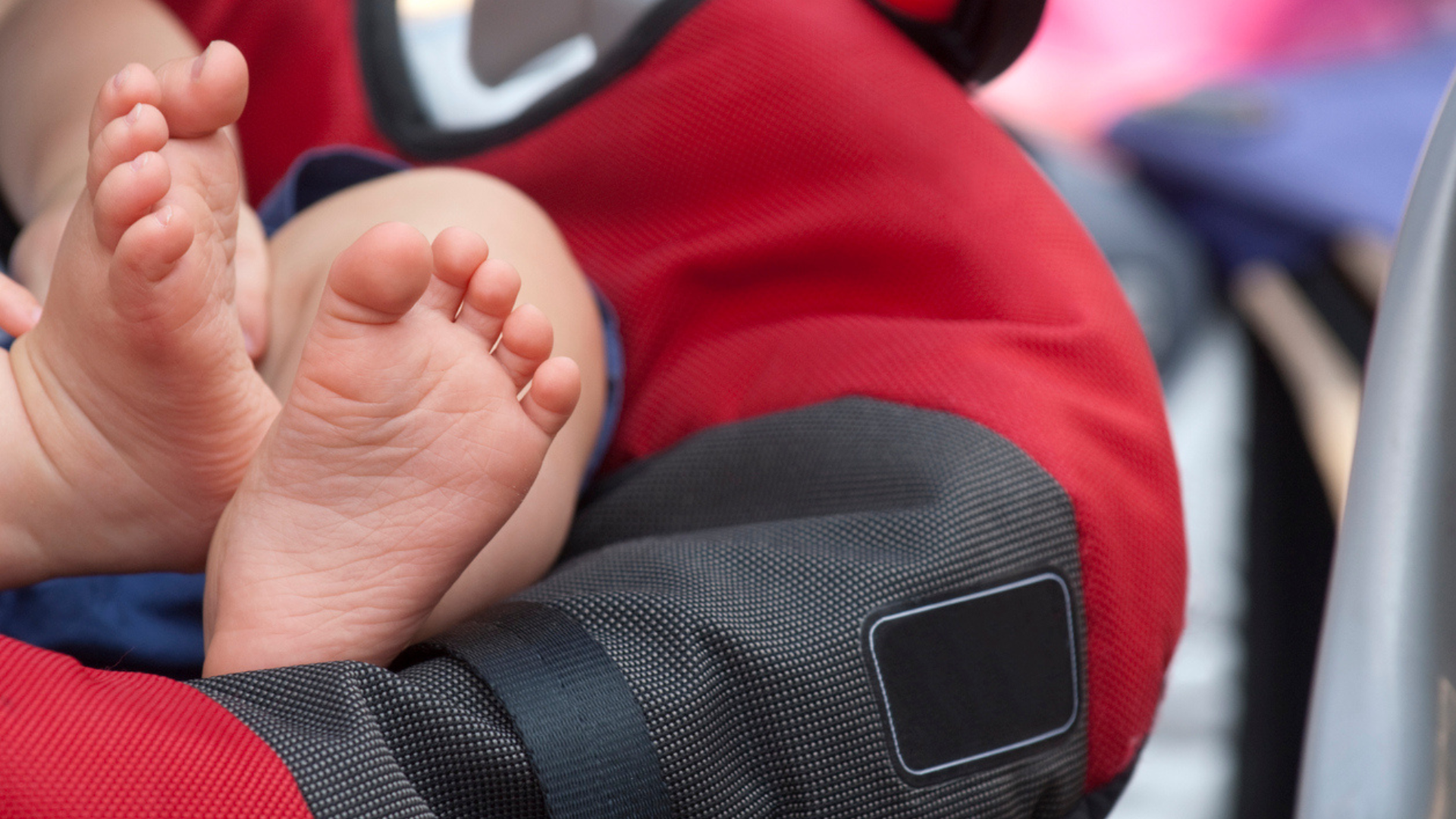 baby's feet in red car seat