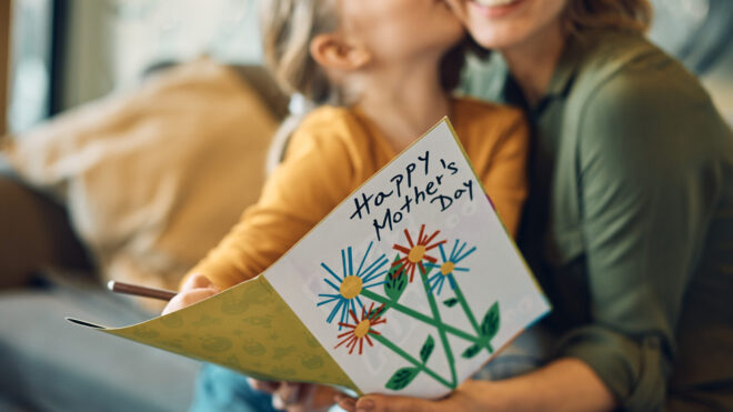 Close-up of woman receiving greeting card from her daughter on Mother's day.