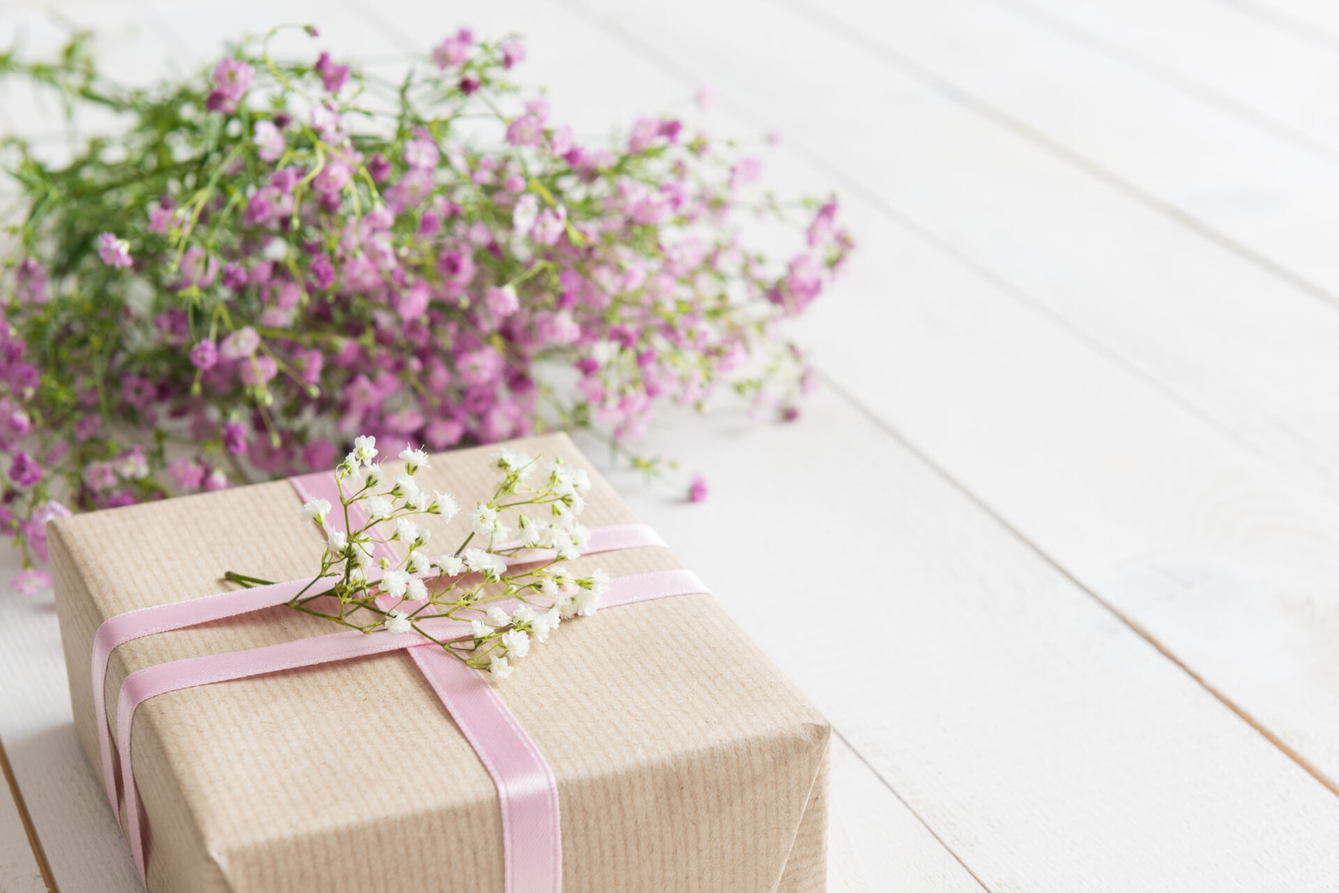 Mother's day, white wooden table with flowers and a present