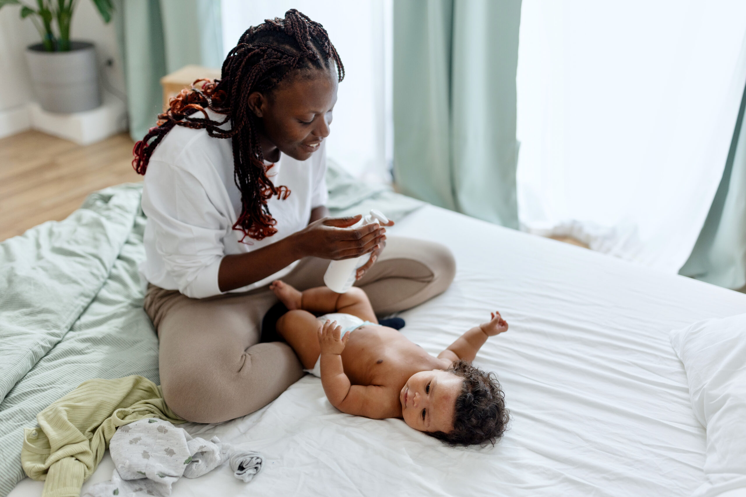 Mother putting dy lotion on her baby boy