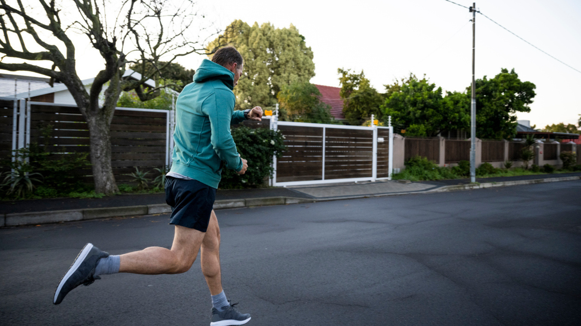 man jogging down neighborhood sidewalk