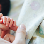 mom holding baby’s finger