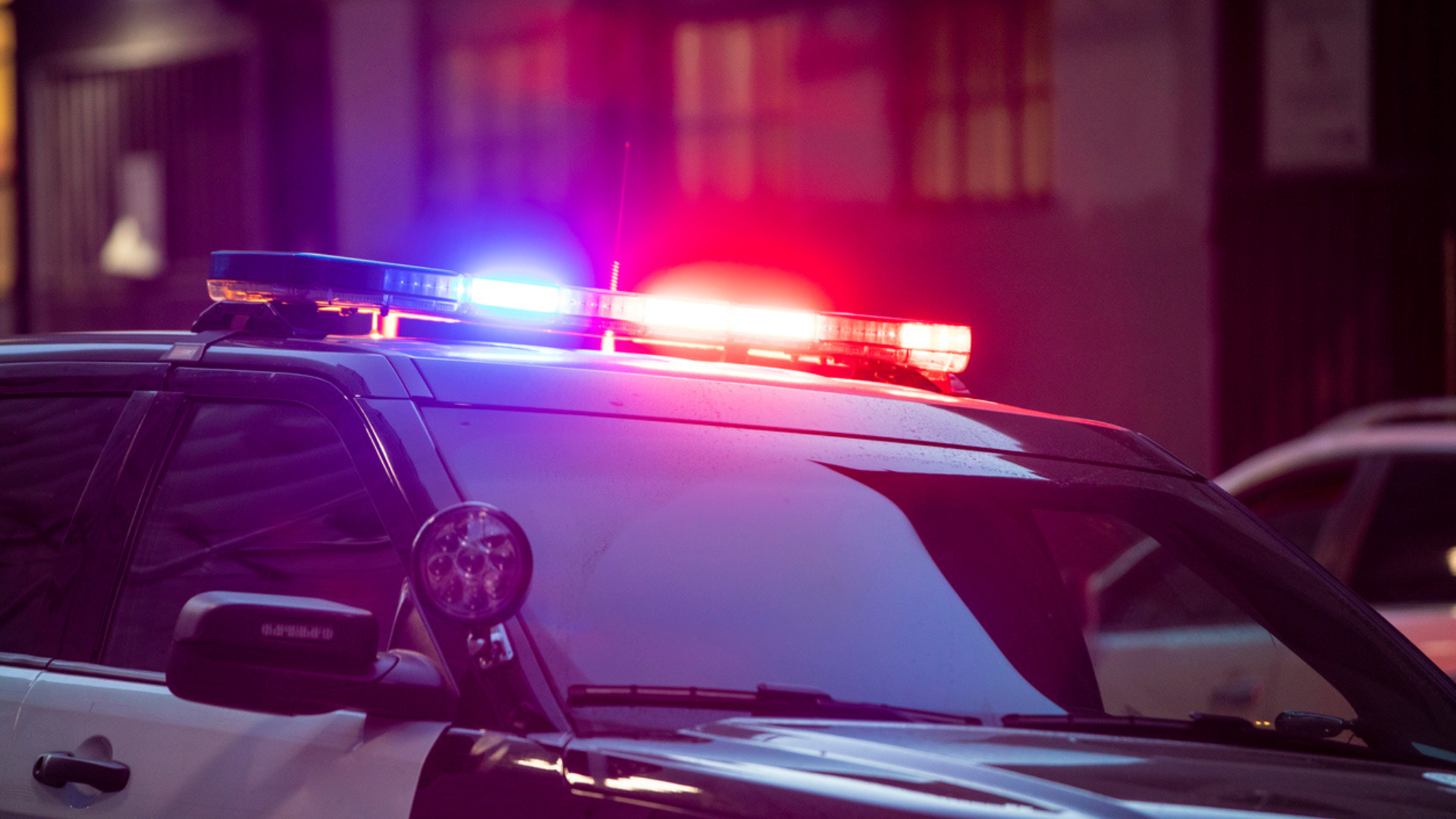 black and white police car with blue and red lights on top
