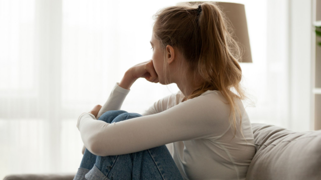 sad woman sitting and looking out a window