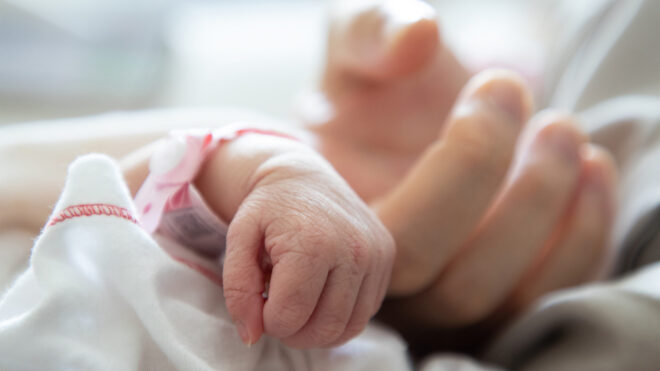 new born baby hand hold mum index finger. concept : Premature or preterm baby in the hospital. relationship between mother and baby.
