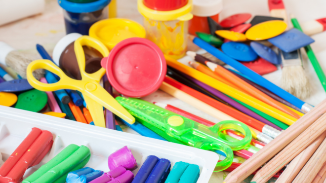 scissors, paints, colored pencils and clay in kindergarten classroom